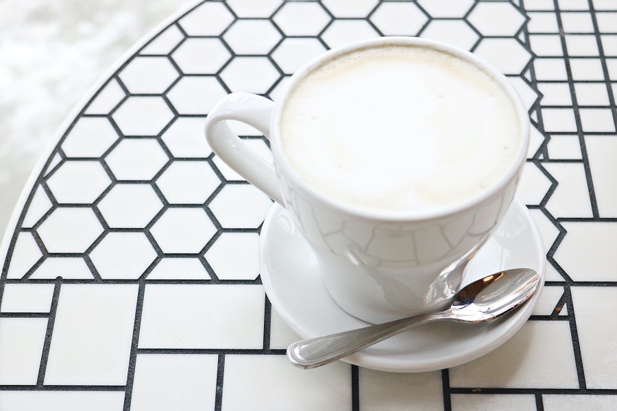 High Protein Grocery List  Close Up of a Cup of Milk on a Saucer with a Small Spoon