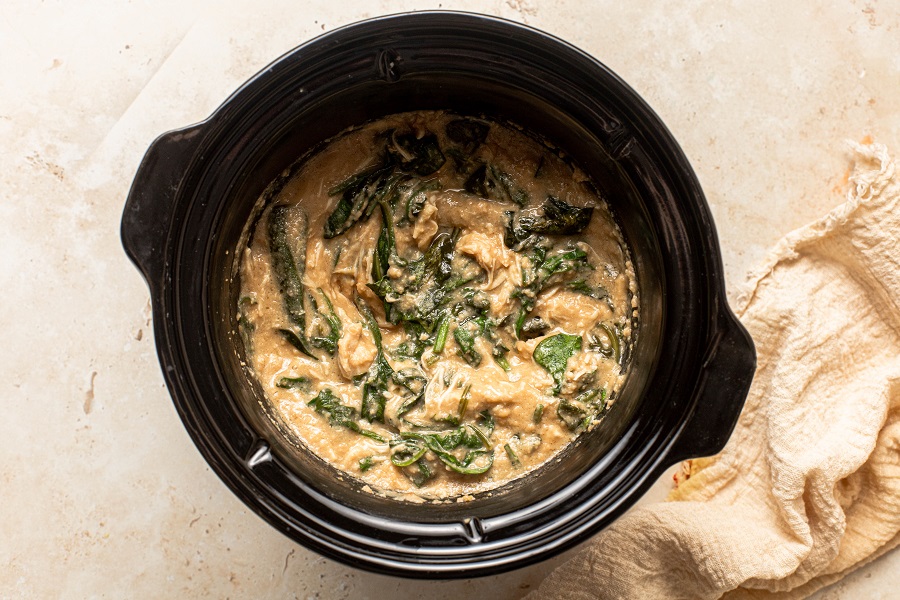 Slow Cooker Chicken and Spinach Rice Bowl Recipe Overhead View of a Crockpot Filled with Chicken, Broth, and Spinach