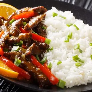 Crockpot Pepper Steak Recipes Close Up of a Plate of Pepper Steak with Rice and Orange Slices