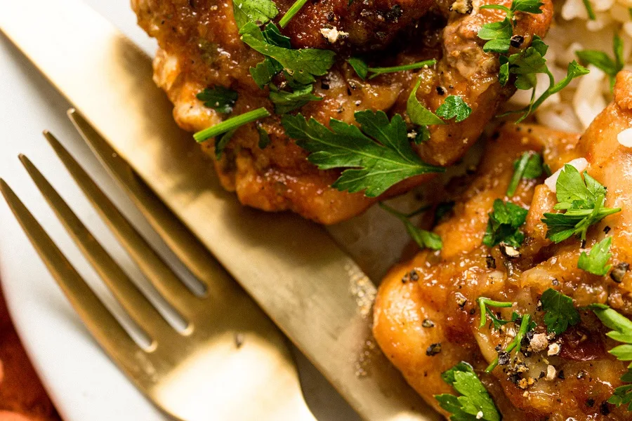 Slow Cooker Chicken Teriyaki Freezer Meal Recipe Close Up of a Fork Next to a Plate of Teriyaki Chicken