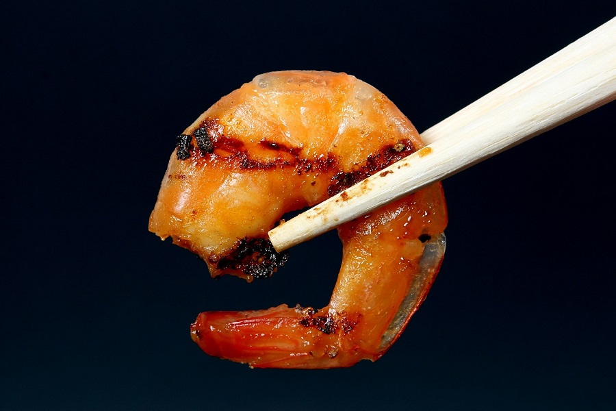 Instant Pot Shrimp Recipes Close Up of a Single Shrimp Being Held by Chopsticks