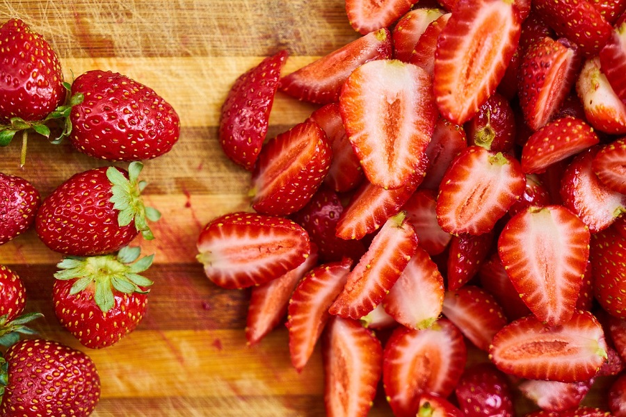 Crockpot Summer Dessert Recipes Close Up of Strawberries on a Cutting Board