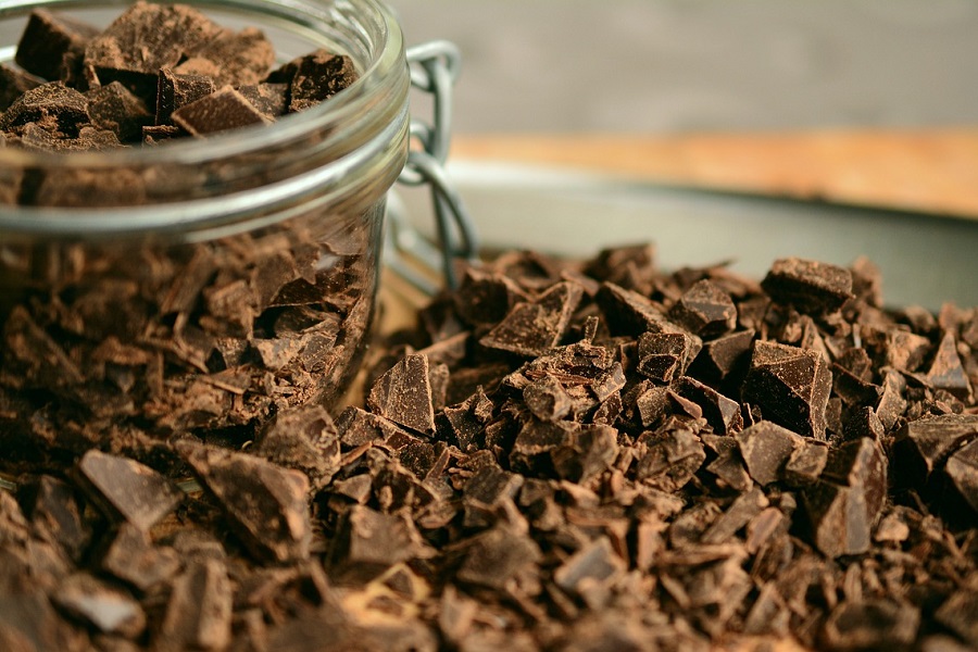 Crockpot Summer Dessert Recipes Close Up of Shredded Chocolate Next to a Small Jar of Chocolate Chunks