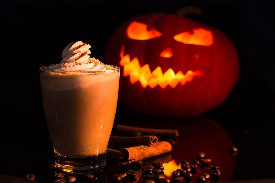 Funny Pumpkin Spice Memes a Pumpkin Spice Latte Topped with Cream and a Jack-O-Lantern in the Background