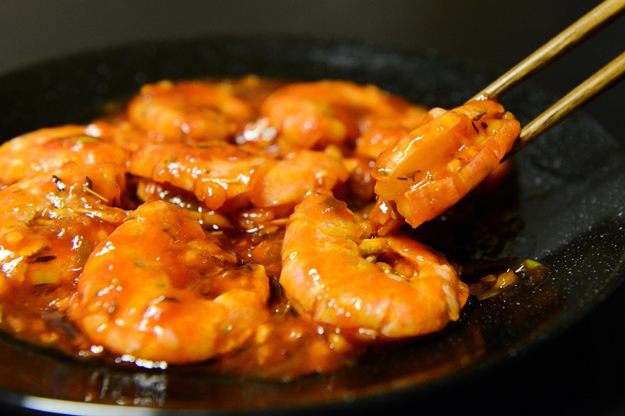 Crockpot Dinner Recipes with Shrimp Close Up of Shrimp on a Plate with a Chopstick Grabbing One