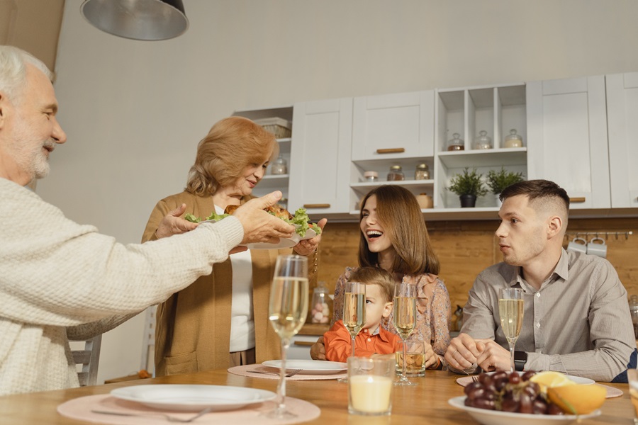 Best Crockpot Thanksgiving Sides a Family Serving Thanksgiving Dinner at a Table in a Kitchen