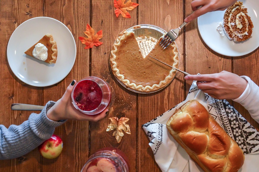 Best Crockpot Thanksgiving Sides Overhead View of a Table with a Pumpkin Pie Being Cut and Served