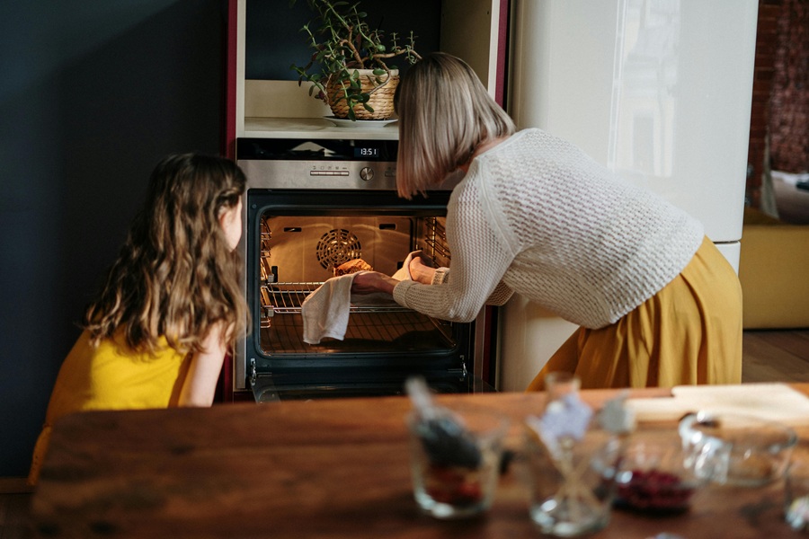 Best Crockpot Thanksgiving Sides a Grandmother and a Granddaughter Pulling Something from an Oven Together