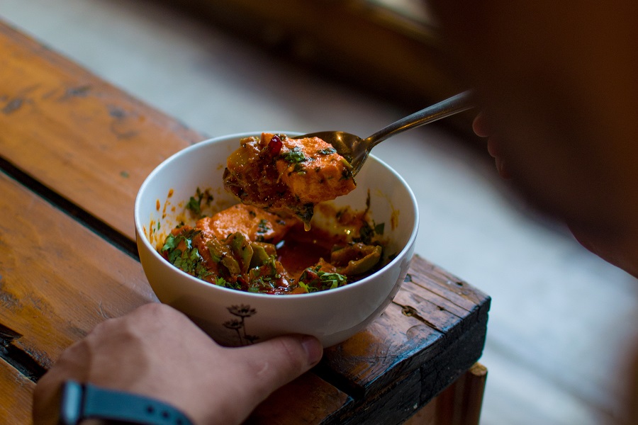 Crockpot Stews with Chicken Overhead View of a Bowl Filled with Stew Being Eaten by a Person Out of Sight