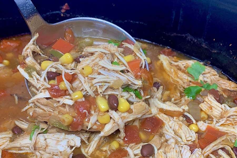 Easy Slow Cooker Soups with Chicken Close Up of a Ladell in a Crockpot Filled with Chicken Tortilla Soup