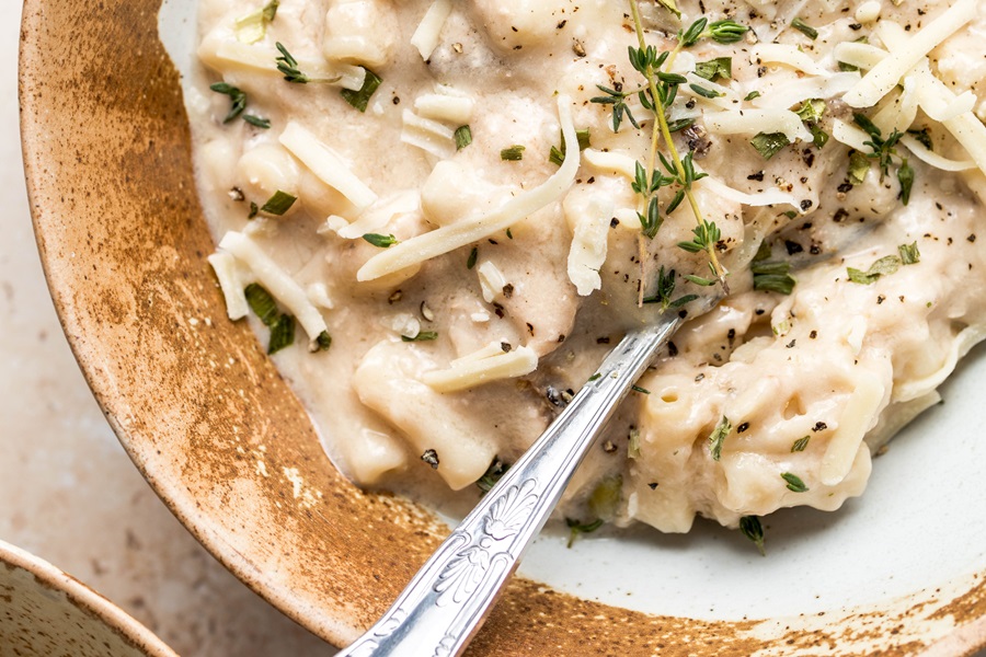 Easy Leftover Turkey and Noodles Recipe a Bowl of Casserole with a Spoon Topped with Thyme