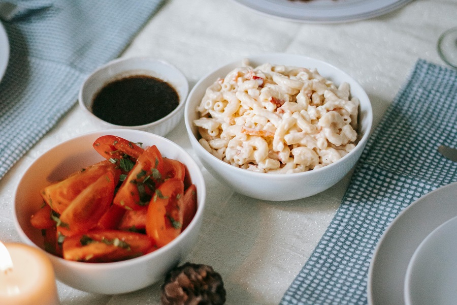 Instant Pot Summer Side Dish Recipes Close Up of a Bowl of Macaroni Salad Next to a Small Bowl of Veggies on a Table