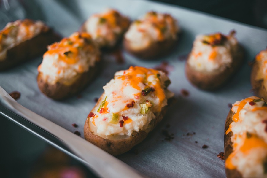 Instant Pot Summer Side Dish Recipes Close Up of a Baking Tray Filled with Twice Baked Potatoes Uncooked