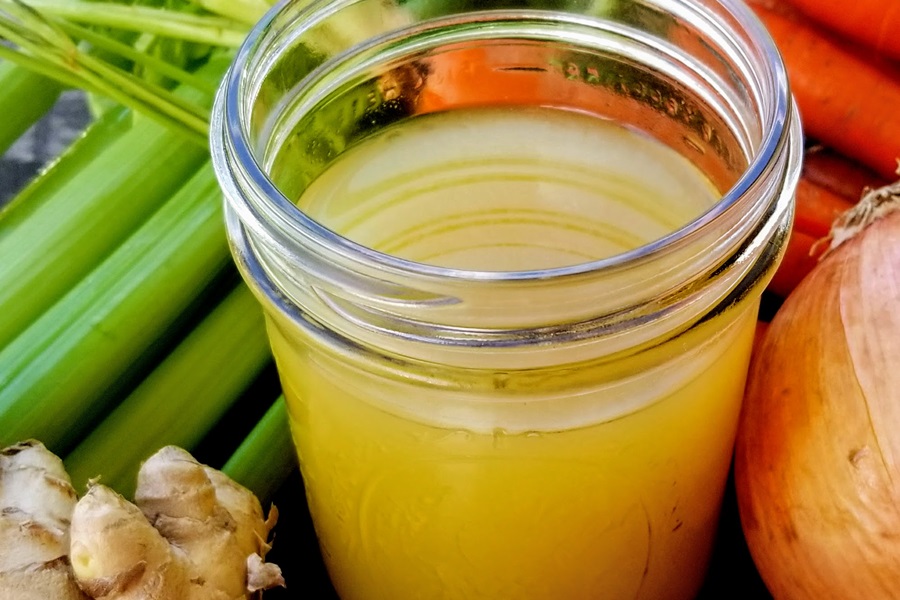 Keto Chicken Bone Broth Recipe Close Up of a Jar of Bone Broth Surrounded by Ingredients