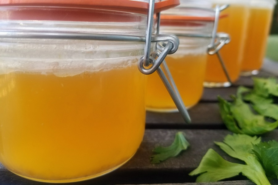 Keto Chicken Bone Broth Recipe Close Up of a Row of Jars Filled with Bone Broth