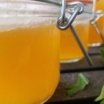 Keto Chicken Bone Broth Recipe Close Up of a Row of Jars Filled with Chicken Bone Broth