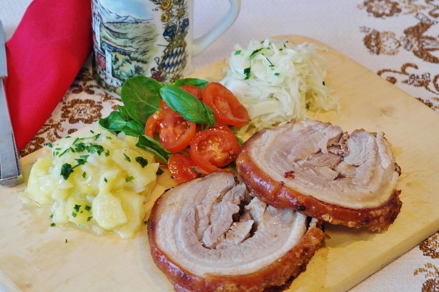 Can I Put a Frozen Pork Roast in the Crockpot Sliced Pork on a Wooden Cutting Board with Potato Salads and Tomatoes