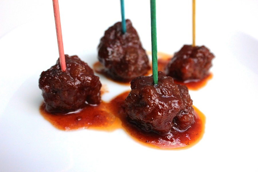 How to Cook Frozen Uncooked Meatballs Close Up of Four Small Meatballs Each with a Different Colored Toothpick in Each Ball
