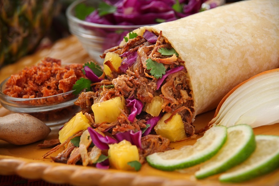 Mexican Barbacoa Recipe Ideas Close Up of a Burrito Cut Open with Shredded meat, Mango Salsa, and Cilantro Spilling Out