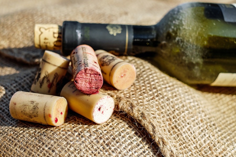 What Wine Goes with Shrimp Scampi Close Up of a Bottle of Wine Next to a Pile of Corks on a Burlap Surface