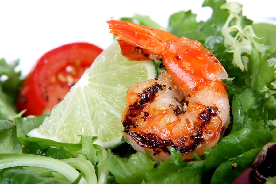 Texas Roadhouse Shrimp Recipe Ideas Close Up of a Single Grilled Shrimp on Lettuce with a Lime Wedge and a Tomato Slice
