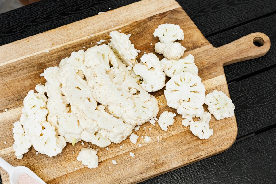 Cauliflower Air Fryer Recipes Cauliflower Sliced into Pieces on a Wooden Cutting Board