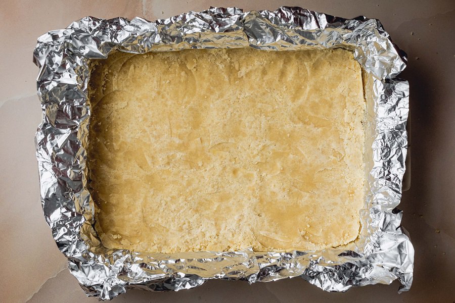 Easy Lemon Bars Recipe Overhead of Lemon Bars Finished Baking and Cooling Off in a Foil Baking Pan