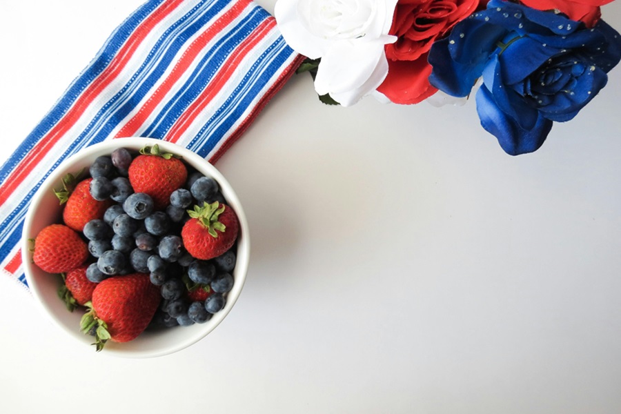 Easy Patriotic Food Appetizers for a Party a Small Bowl of Berries on a Red, White and Blue Towel Next to Red, White and Blue Flowers