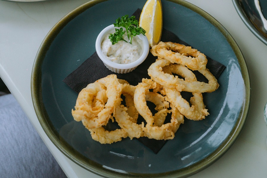 How to Reheat Calamari in an Air Fryer a Small Plate Filled with Calamari with a Lemon Wedge and a Small Dipping Sauce