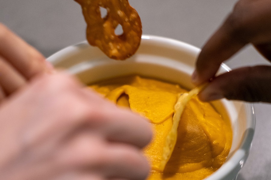 Recipes with Queso Dip  Close Up of People Dipping Chips into a Cheese Dip