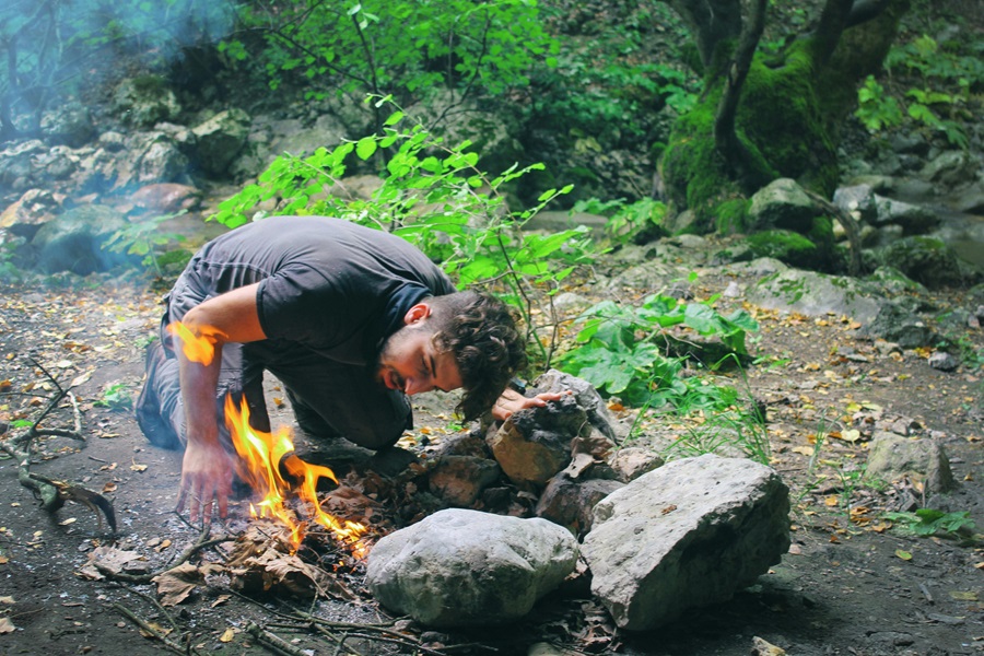 Cast Iron Cooking Recipes a Man Building a Campfire at a Campsite