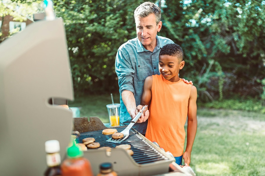 Summer Dinner Recipes for the Grill a Man Helping a Young Kid Learn How to Grill By Holding a Spatula and Flipping Meat on a Grill in a Yard