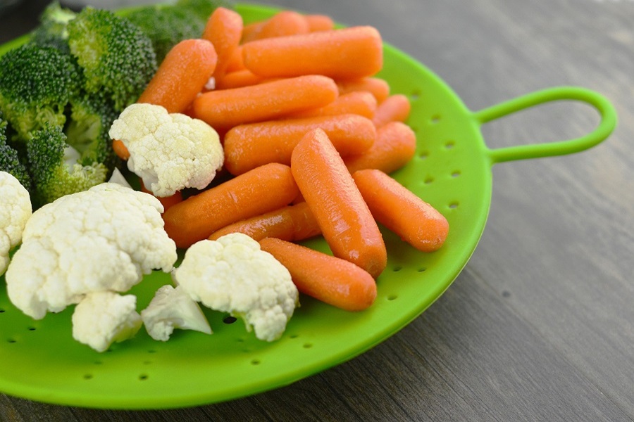 Instant Pot Cauliflower Recipes A Green Plate with Cauliflower, Carrots, and Broccoli on it