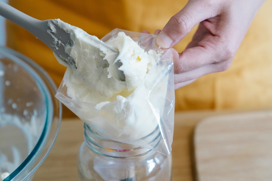 Super Easy Summer Dessert Recipes Close Up of a Person Filling a Piping Bag with Whipped Cream
