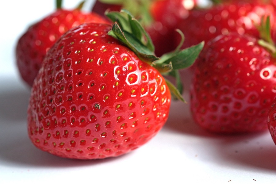 Super Easy Summer Dessert Recipes Close Up of Strawberries on a White Surface
