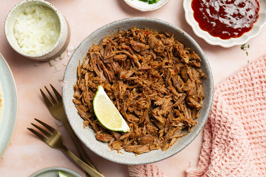 A Plate of Easy Crockpot Beef Barbacoa with a Lime Wedge 