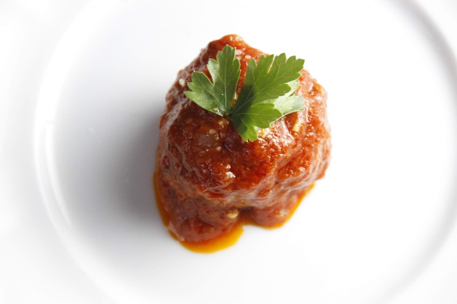 Easy Crockpot Meatballs Dinner Recipe a Single Meatball on a Plate with Marinara Sauce and a Parsley Leaf