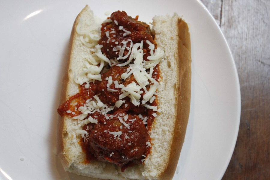 Easy Crockpot Meatballs Dinner Recipe a Meatball Sub Sandwich on a White Plate