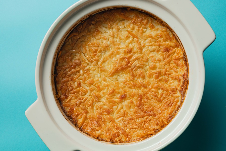 Easy Twice-Baked Mashed Potatoes Recipe Overhead View of a Baking Dish Filled with Twice Baked Potatoes and Topped with Melted Cheddar Cheese