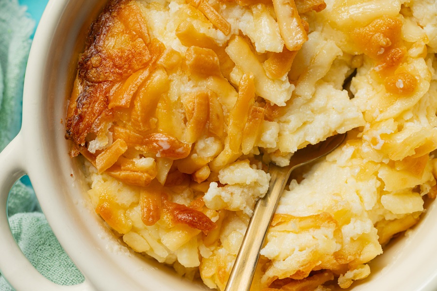 Easy Twice-Baked Mashed Potatoes Recipe Close Up of a Dish of Twice Baked Potatoes with a Spoon Inside