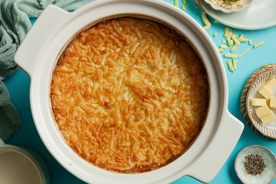 Easy Twice-Baked Mashed Potatoes Recipe Overhead View of a Baking Dish Filled with Twice Baked Potatoes Topped with Cheddar Cheese That Has Been Melted