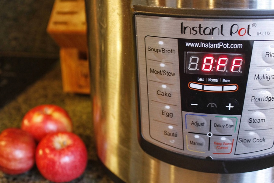 Faster than Stovetop Instant Pot Cinnamon Apples Recipe an Instant Pot Next to Red Apples on a Counter Top