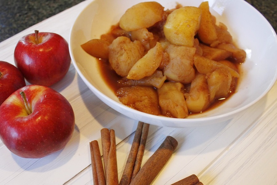 Faster than Stovetop Instant Pot Cinnamon Apples Recipe a Bowl of Cinnamon Apples Next to Red Apples and Cinnamon Sticks