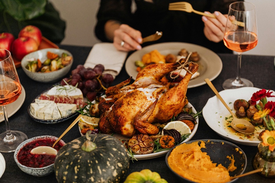 Southern Thanksgiving Recipes Close Up of a Cooked Turkey on a Table with People Sitting Around It