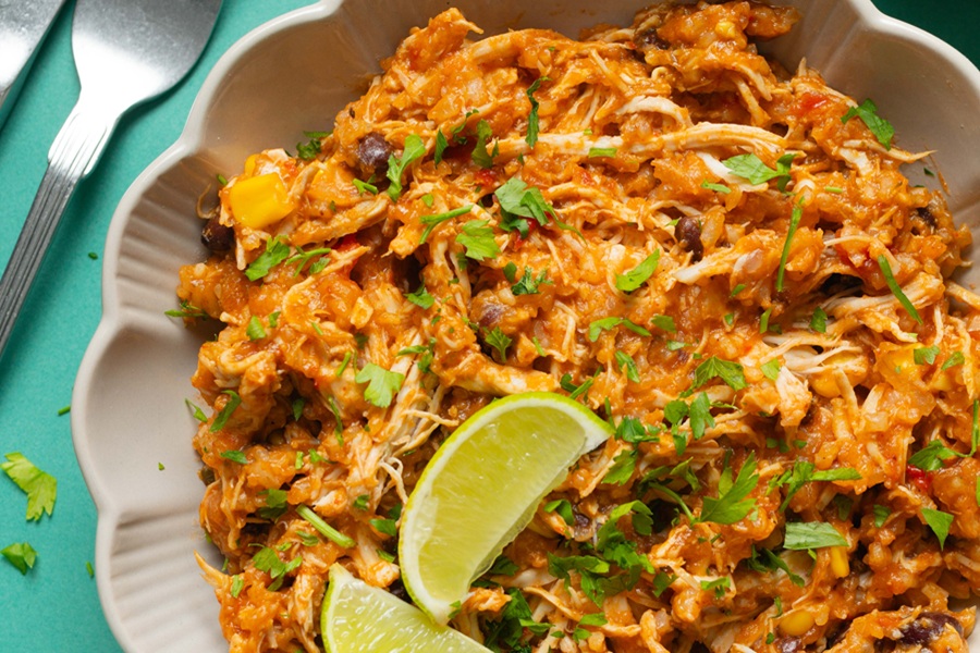 Easy Chicken Tacos in the Slow Cooker Recipe Close Up of Shredded Chicken on a Serving Plater with Two Lime Wedges