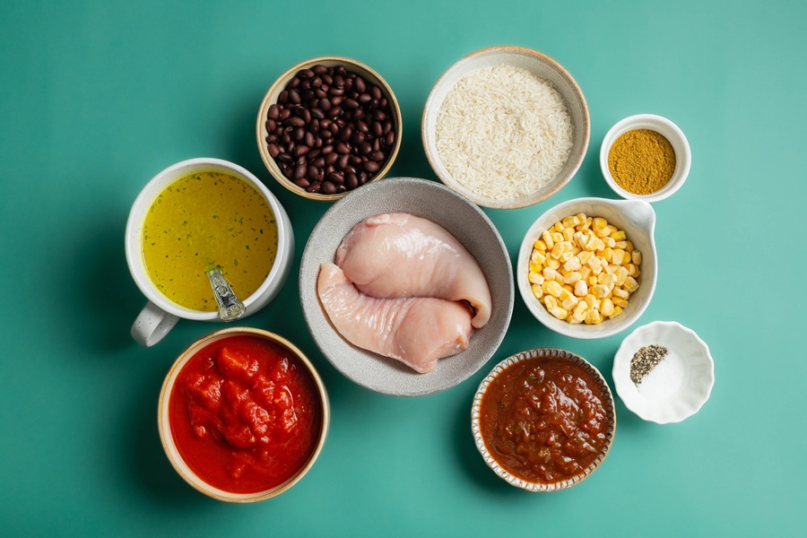 Easy Chicken Tacos in the Slow Cooker Recipe Ingredients Separated Into Small Bowls on a Blueish Green Surface