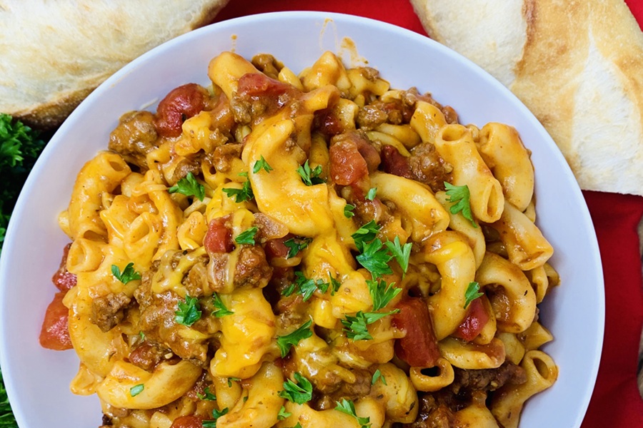 Easy Goulash in the Instant Pot a Plate of Goulash Garnished with Parsley and Two Loaves of French Bread