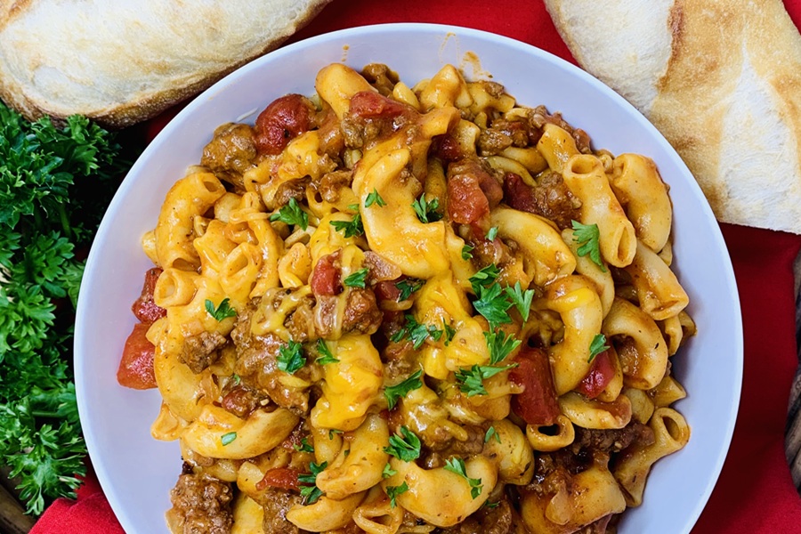 Easy Goulash in the Instant Pot a Plate of Goulash on a Red Table with Fresh Parsley and Bread