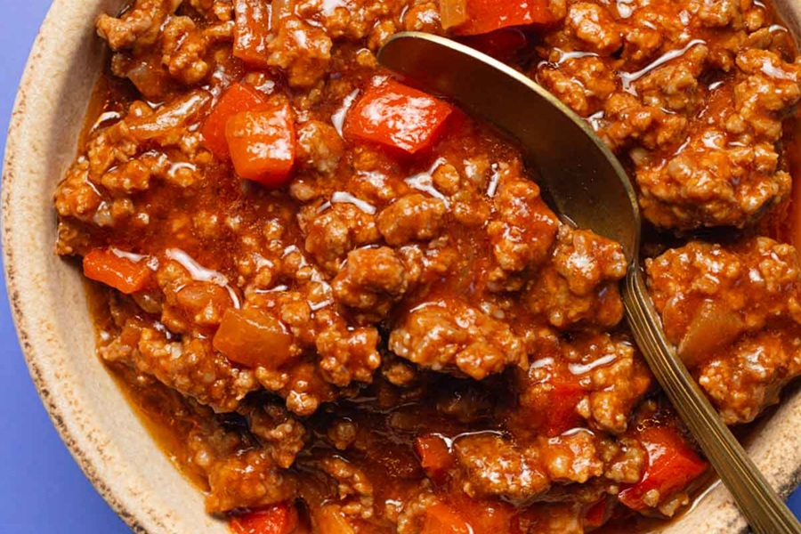 Crockpot Sloppy Joes Recipe Close Up of Meat Mixture in a Bowl with a Spoon