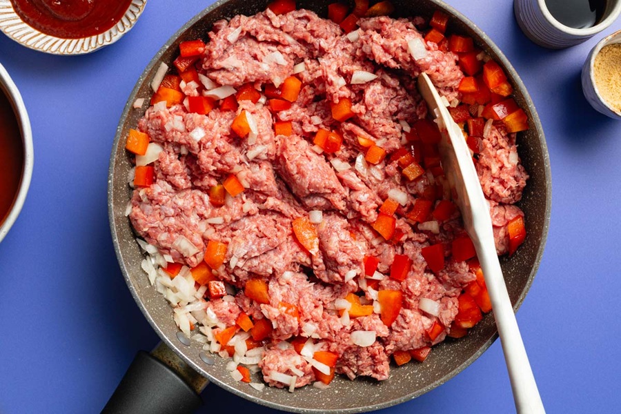 Crockpot Sloppy Joes Recipe Raw Ground Beef in a Pan with Onions and Tomatoes Frying